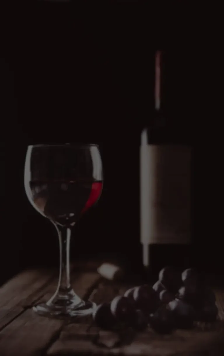 Copa de vino, uvas y una botella es mesa de cata